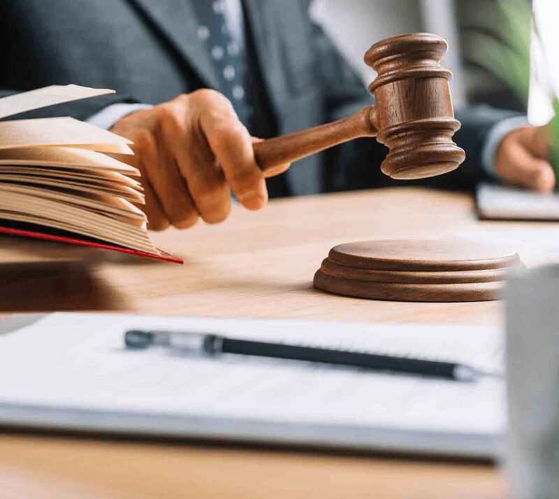 Judge striking gavel with open law book