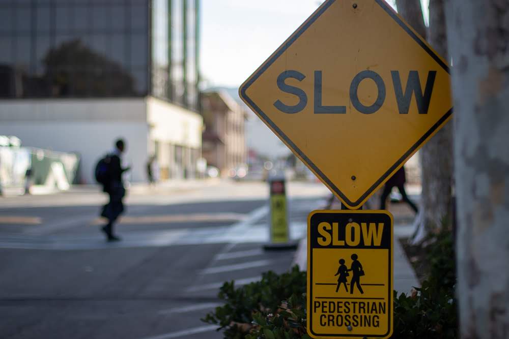 Yellow SLOW pedestrian crossing signs on street
